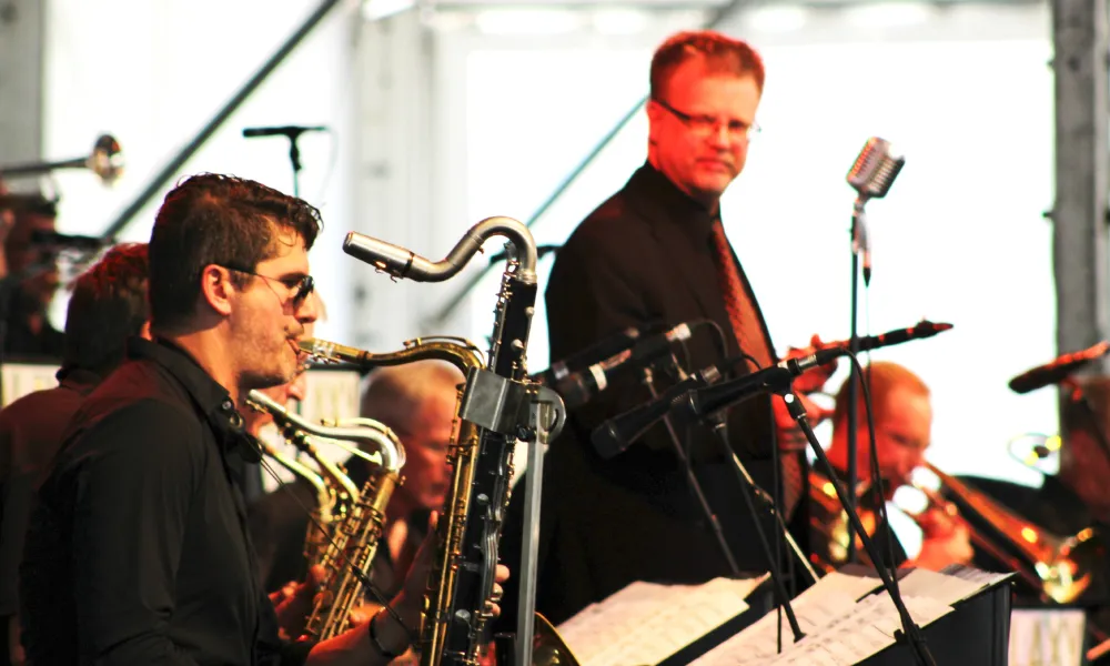 Jazz band on stage under bright lights playing instruments
